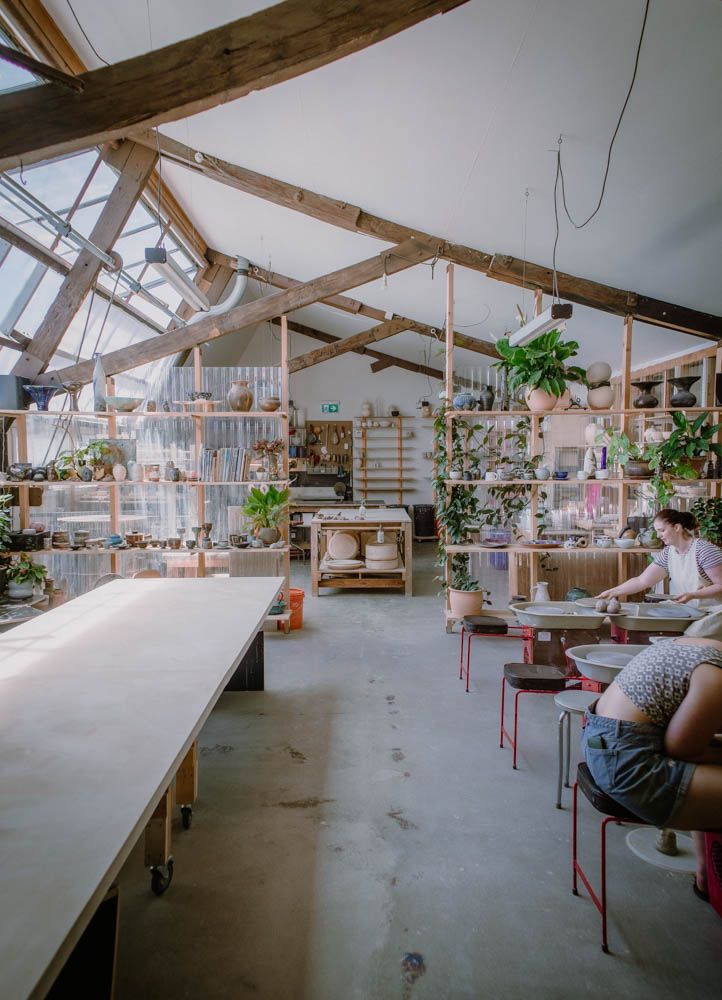 Showing Kiln studio from the front door, large rafters about a spacious studio filled with light and shelving full of ceramics